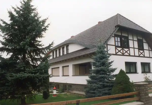 Haus mit Nadelbäumen
